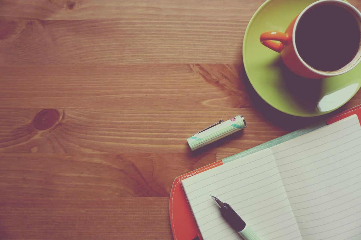 Coin de travail chaleureux avec carnet, tasse et lumière naturelle
